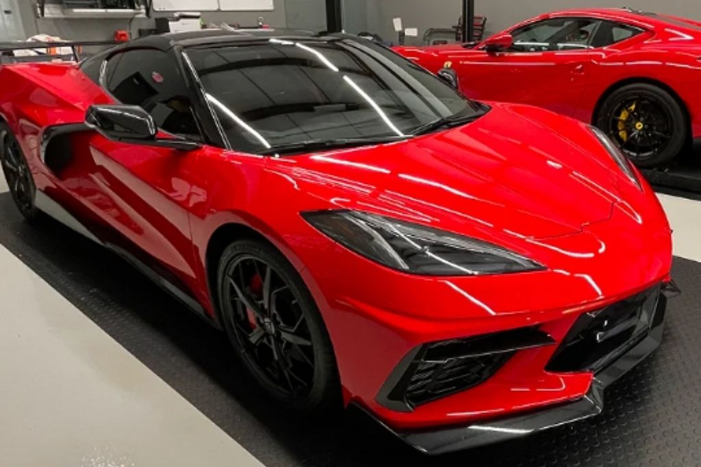 Red Chevrolet Corvette parked indoors after professional detailing with a glossy finish