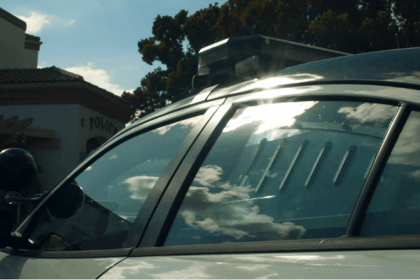 Vehicle side windows reflecting bright sunlight, showing the effect of glare and heat exposure
